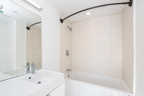 a bathroom with a sink and a tub and a mirror
